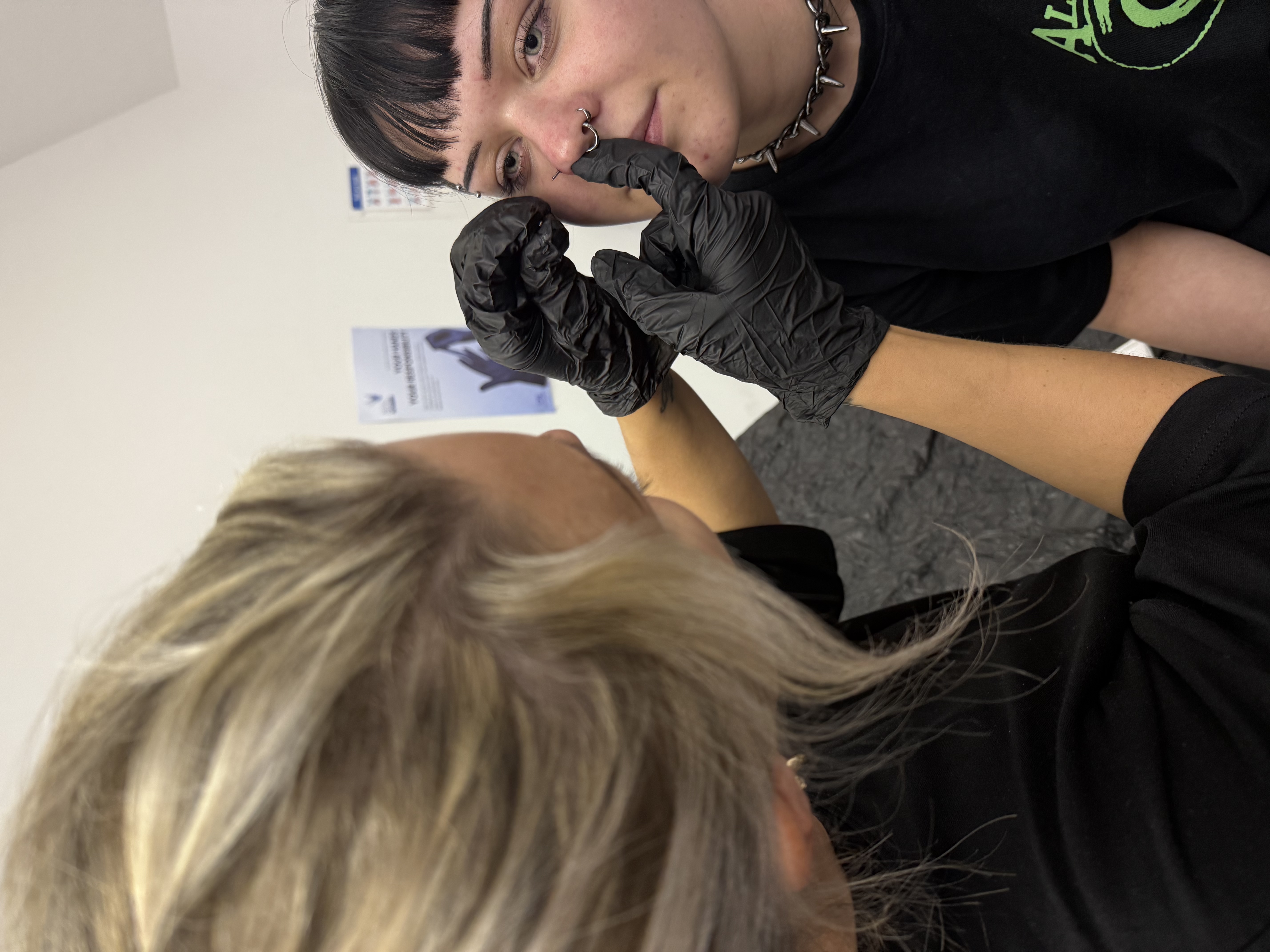 Student performing a piercing during the Hybrid course practical day at Essex Piercing Academy, Romford
